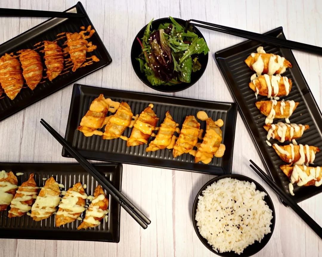 Bunch of Dumplings trays with salad and rice